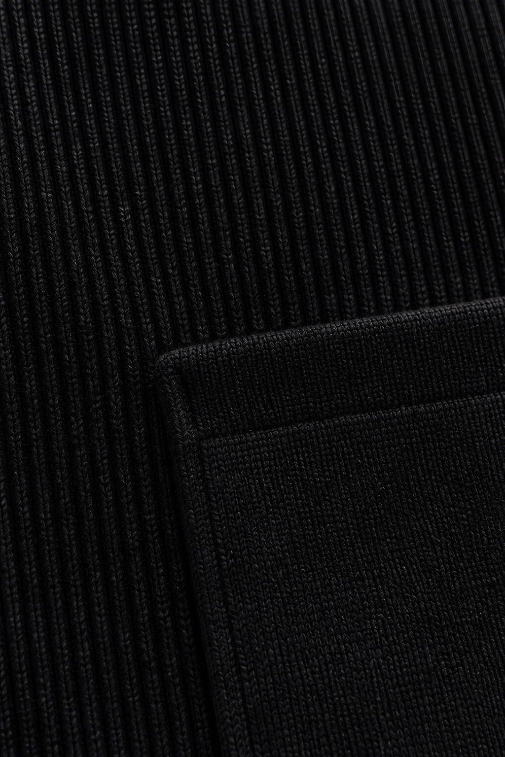 Maille zippée Corniche noir, macro de la matière — visuel généré par IA