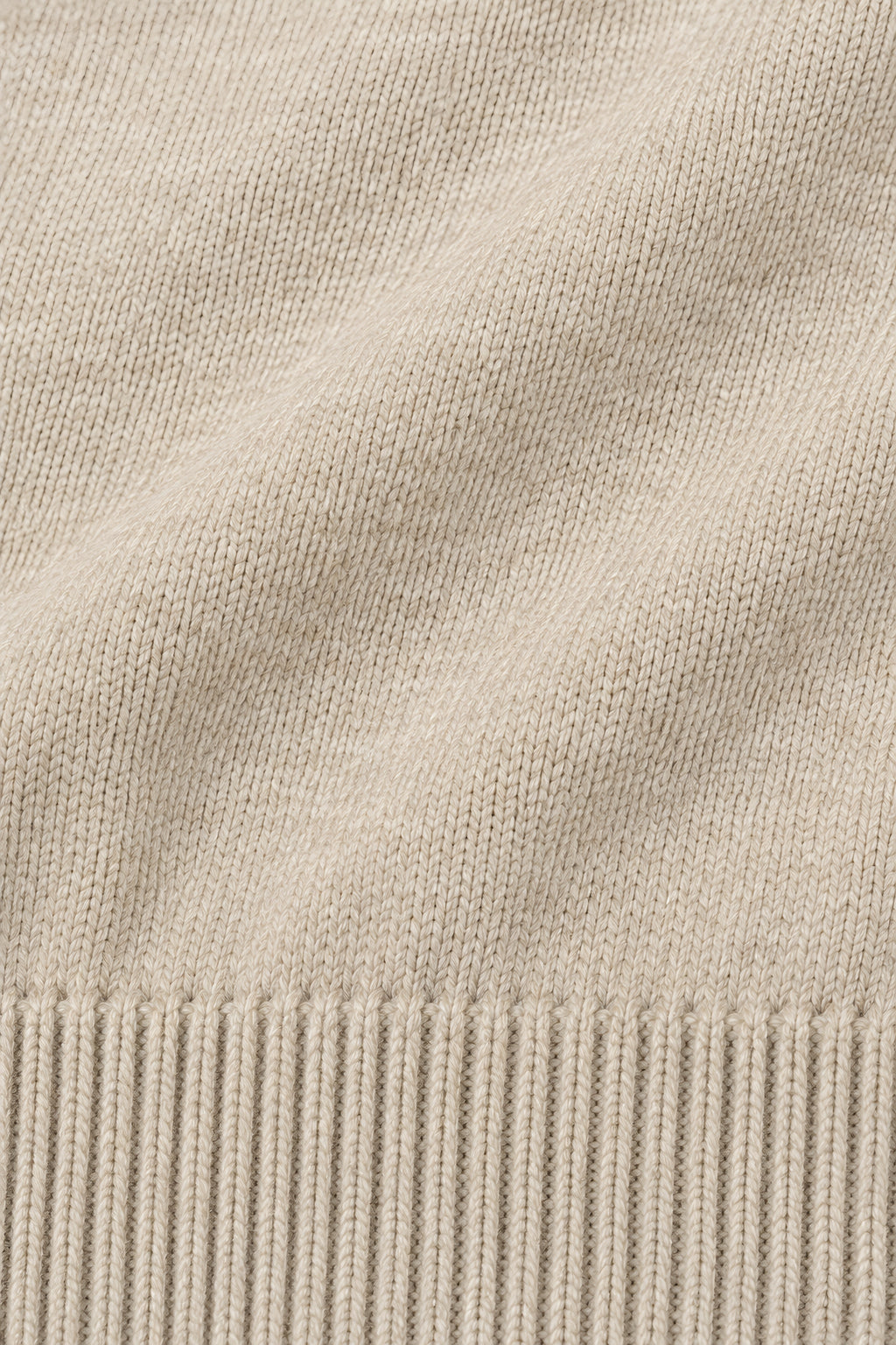 Pull col rond Socle beige, macro de la matière — visuel généré par IA