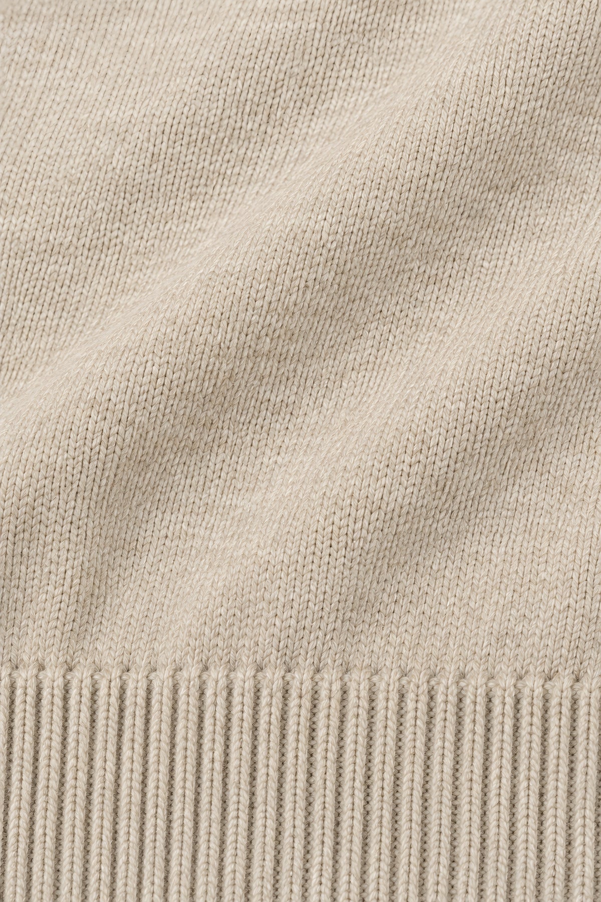 Pull col rond Socle beige, macro de la matière — visuel généré par IA