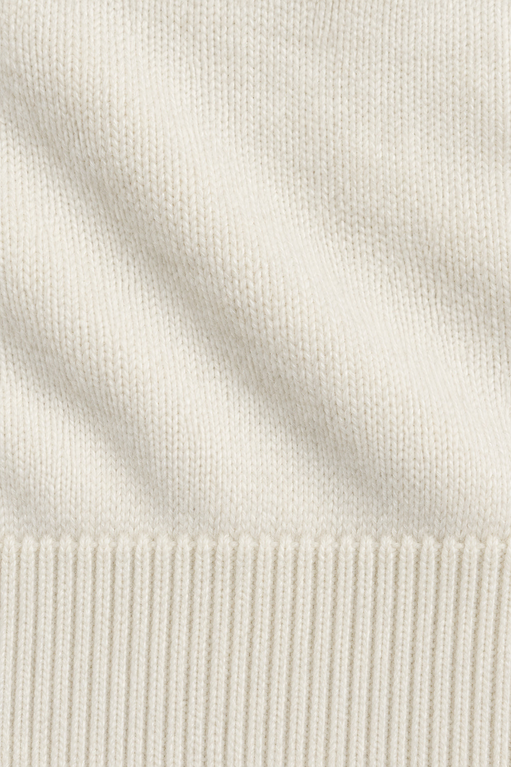 Pull col rond Socle blanc lait, macro de la matière — visuel généré par IA