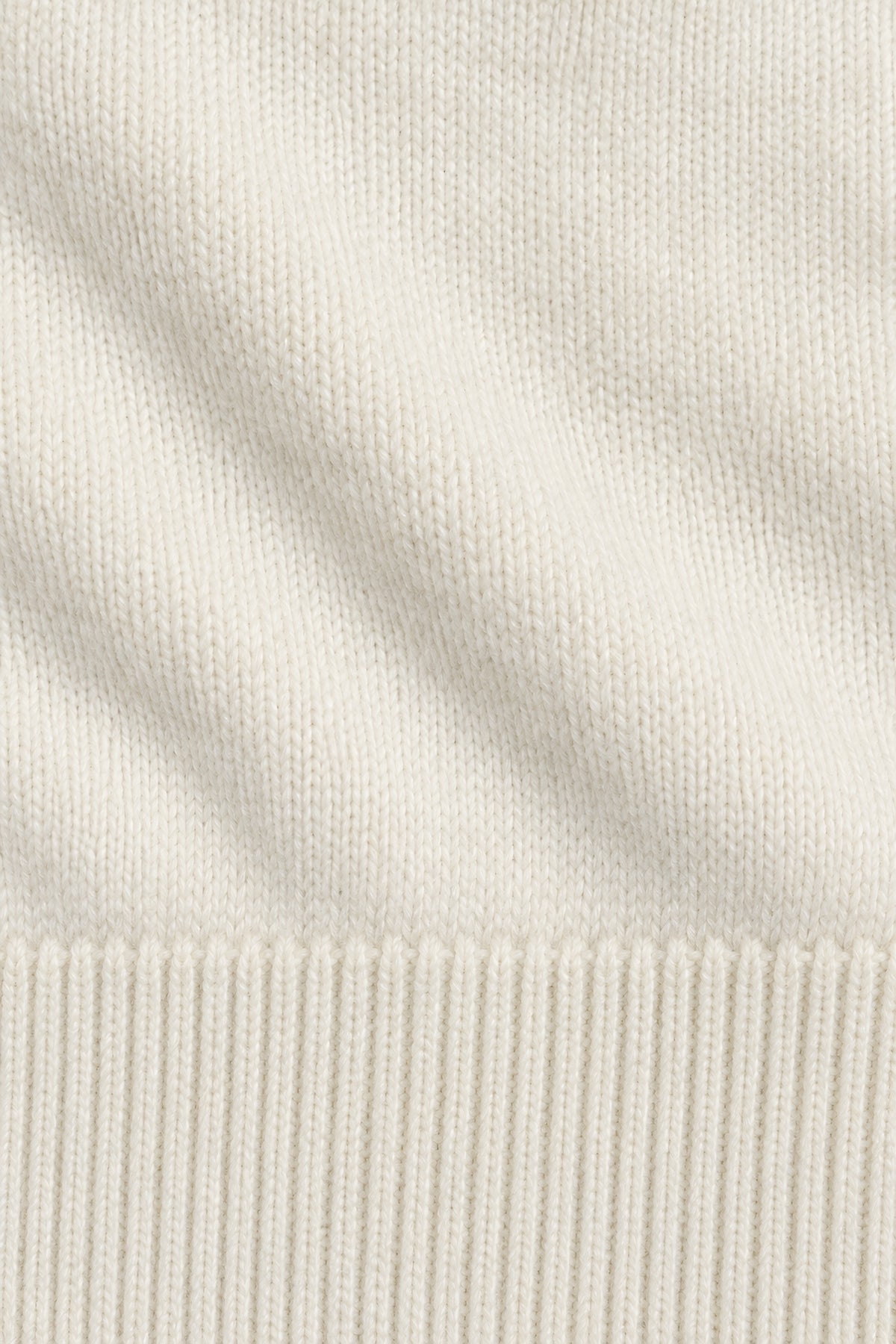 Pull col rond Socle blanc lait, macro de la matière — visuel généré par IA