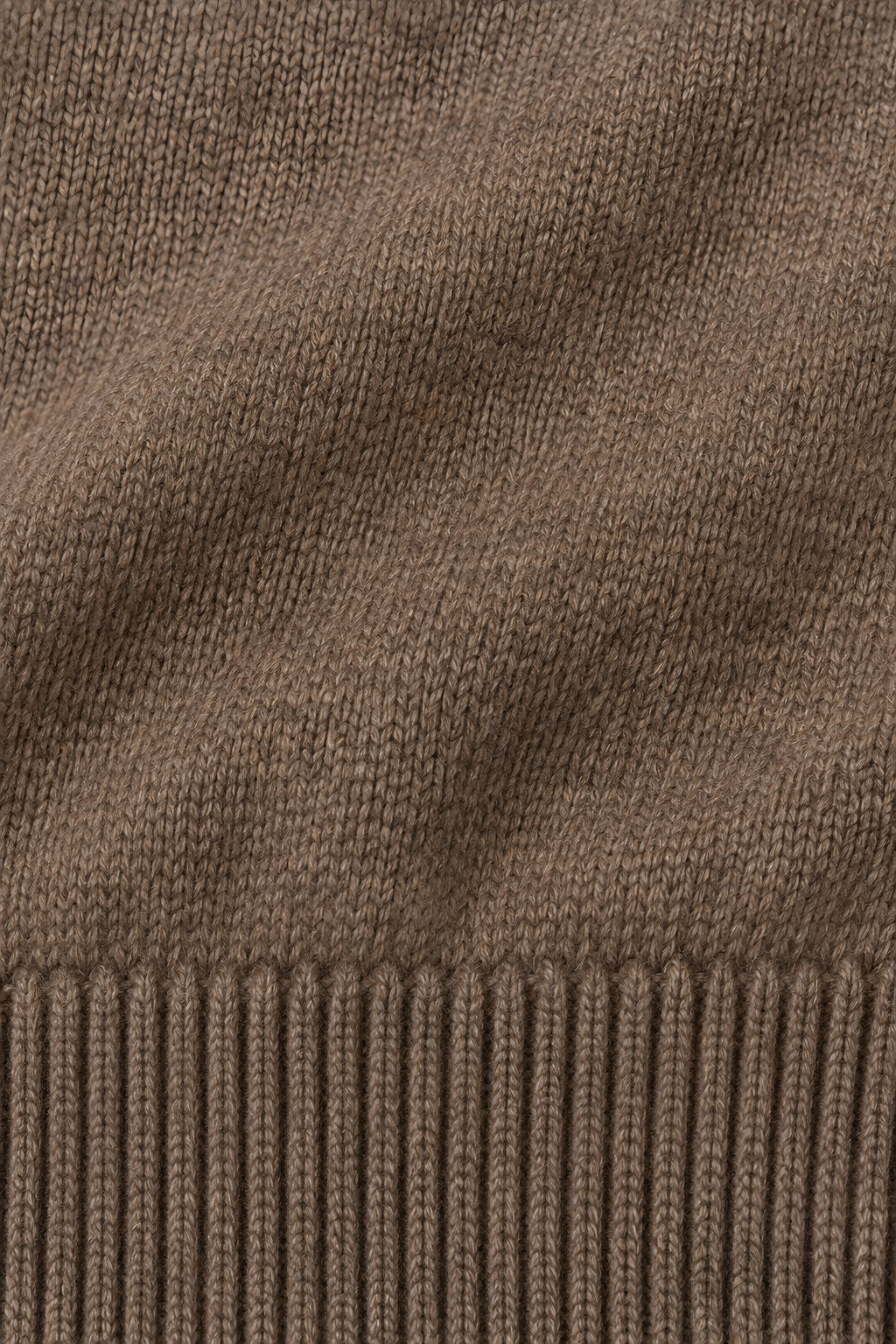 Pull col rond Socle café, macro de la matière — visuel généré par IA